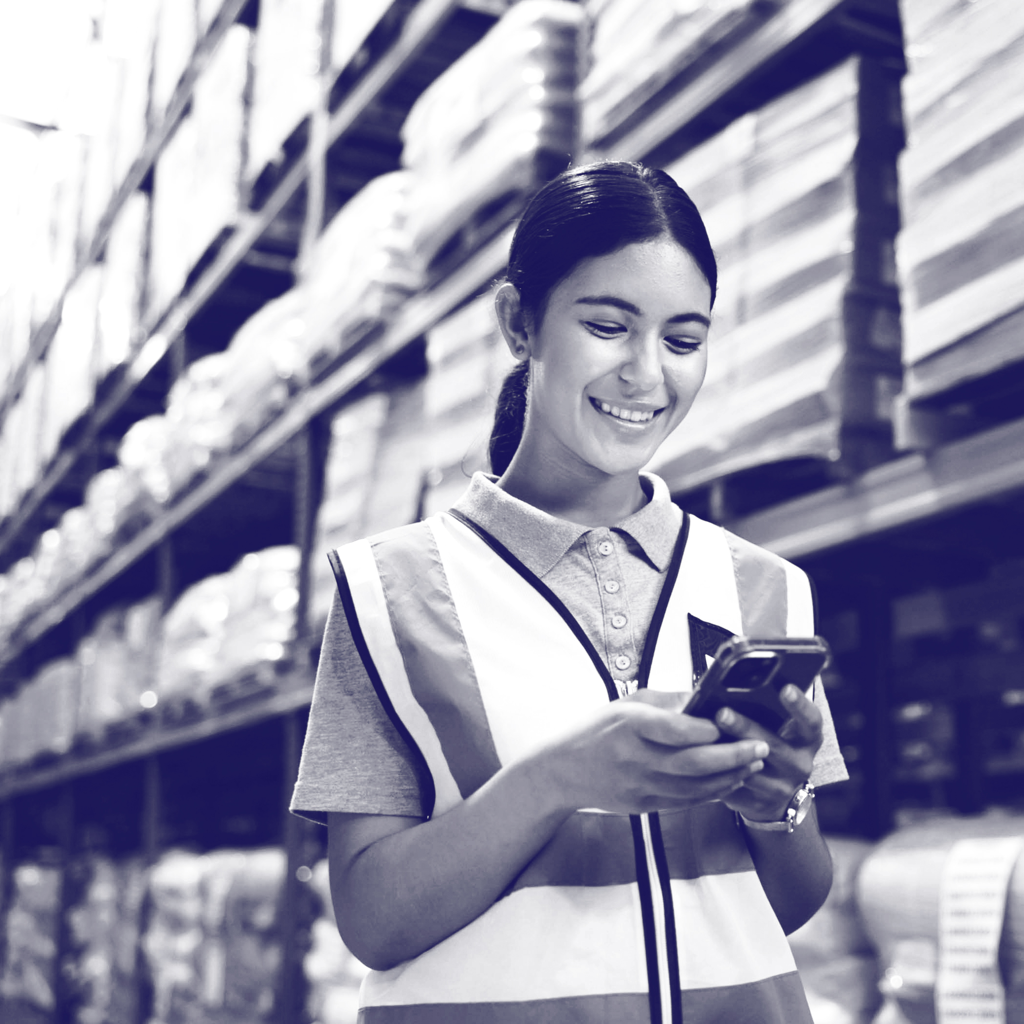 Woman working in warehouse using mobile device